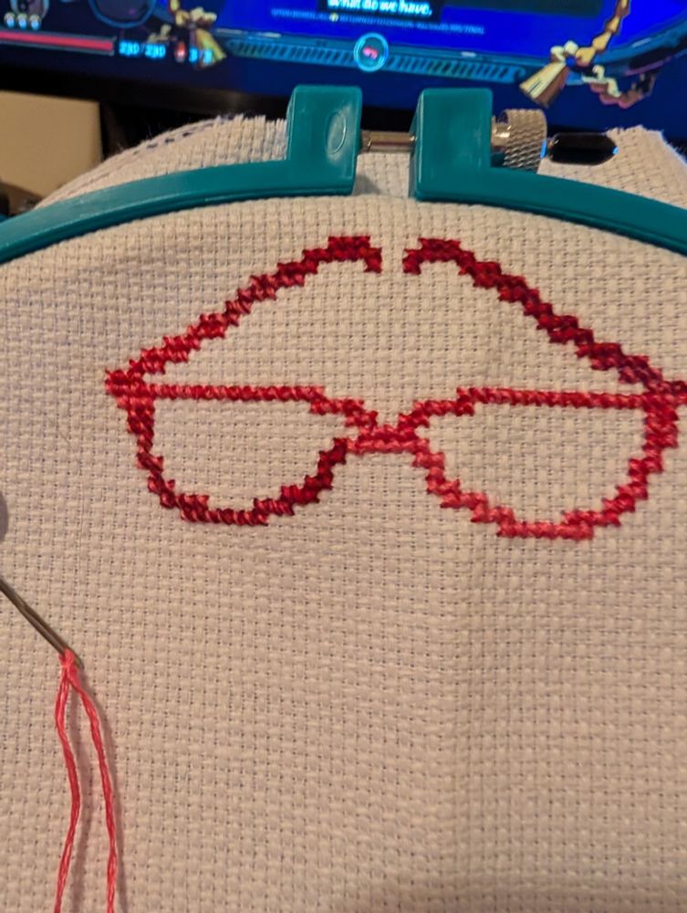 Cross stitch in red. It is a pair of glasses 