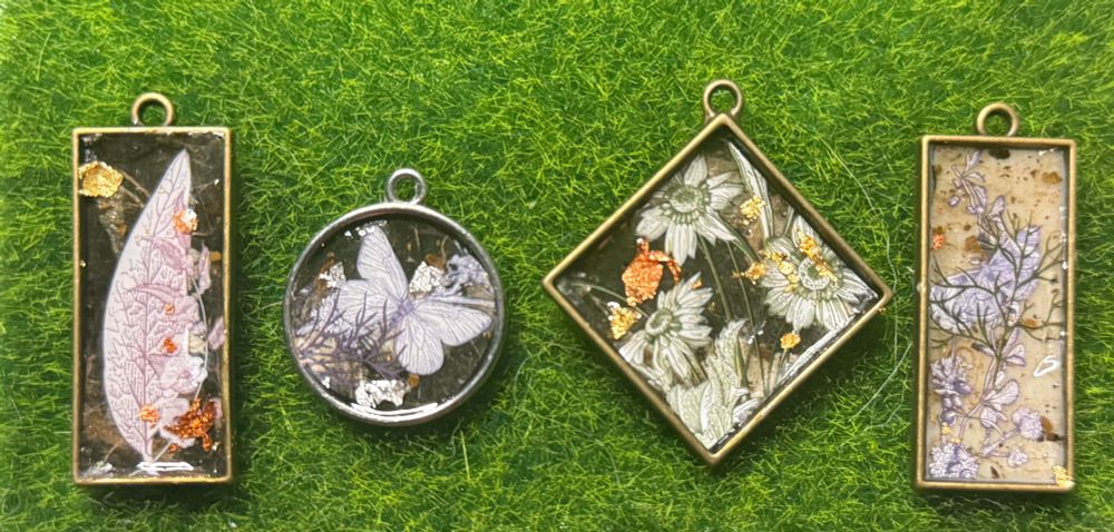 Four bezel pendants with images of various flowers set in resin 