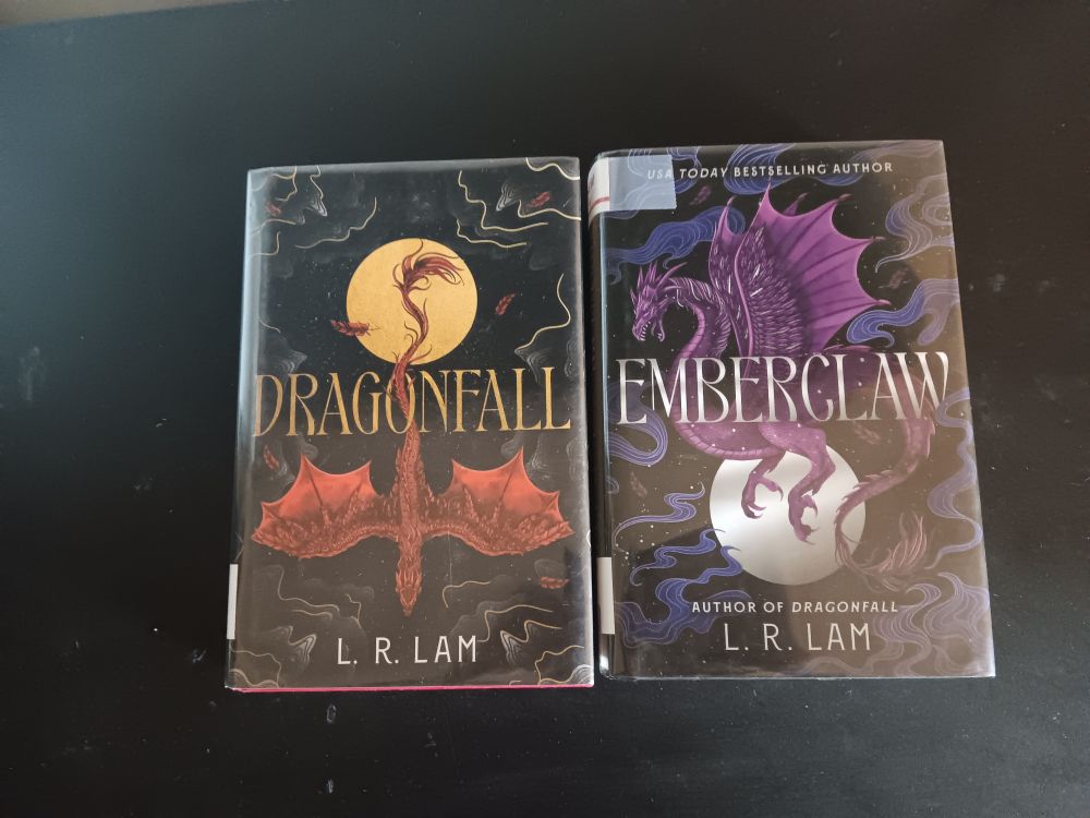 Picture of the Dragon Scales novels in order by L. R. Lam. Dragonfall to the left, and Emberclaw on the right.