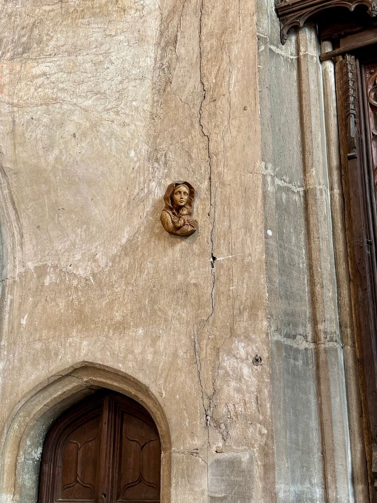 Very small carved figure head and shoulders of Madonna and child on the stone church wall