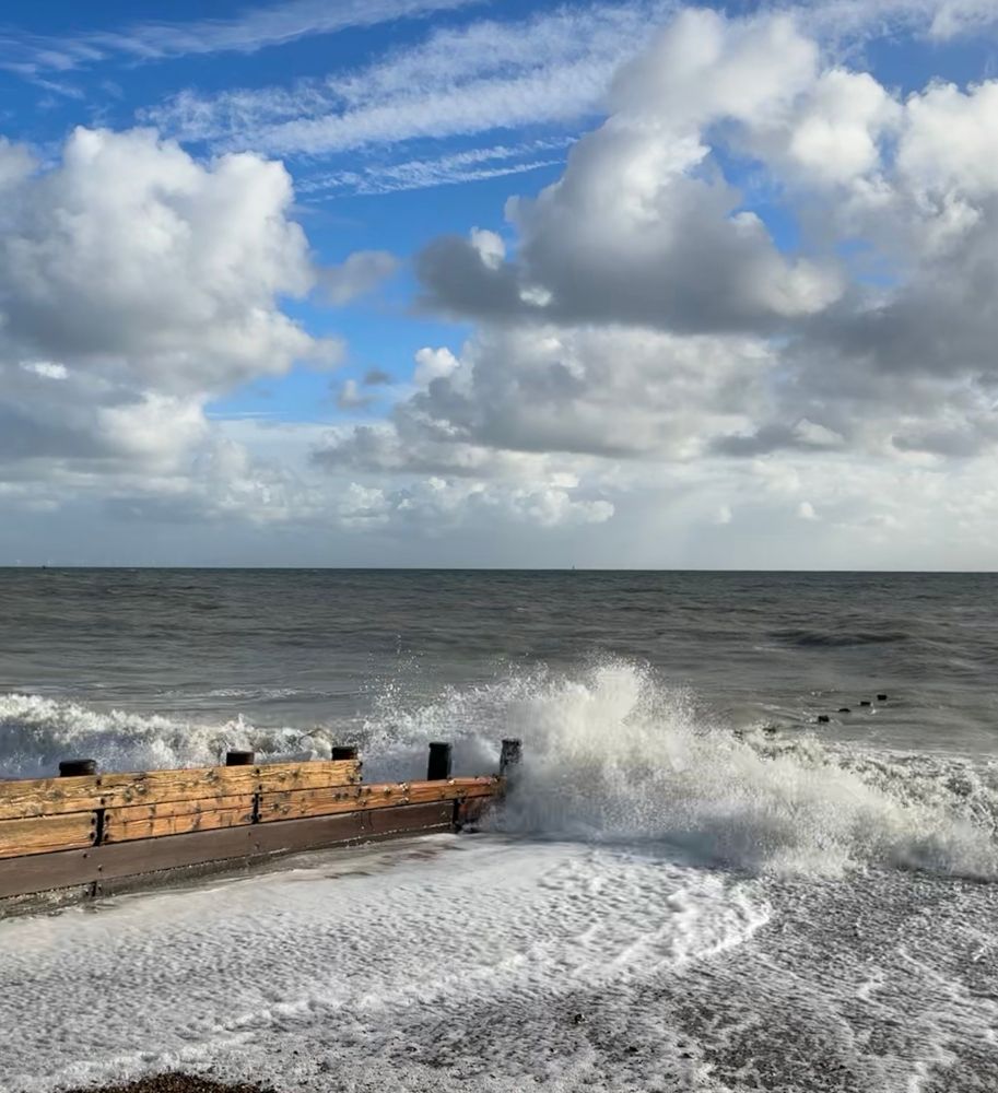 Waves breaking on the wooden groynes - white spray in the air