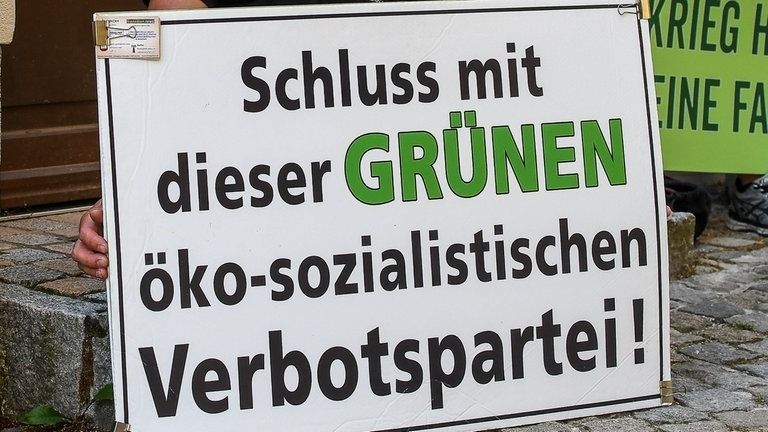 Schild mit Aufschrift "Schluss mit dieser Grünen öko-sozialistischen Verbotspartei!"
