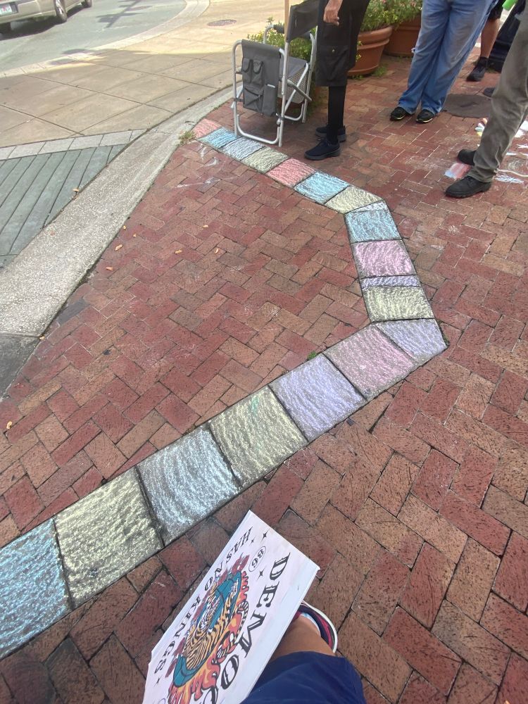 Chalk rainbow added to crosswalk pathway. 