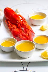 lobster surrounded by butter dipping dishes
