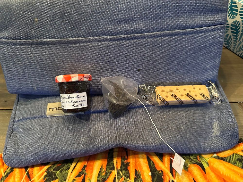 A little pot of jam, a shortbread cookie and a bag of tea 