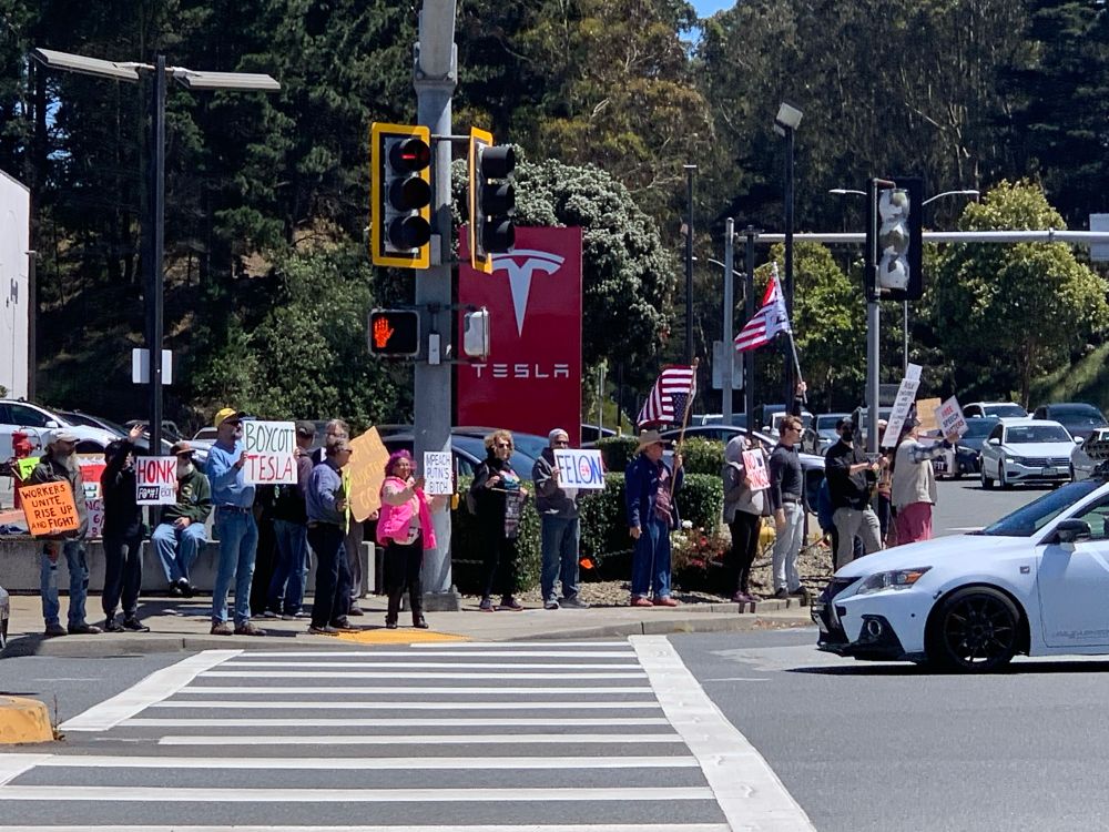 This is a picture of protestors outside of Colma Tesla. 