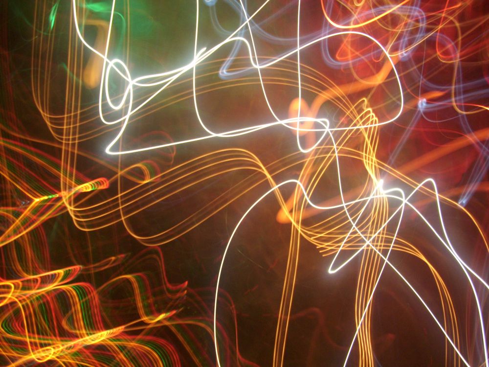 Blick auf die Bühne beim Aufritt einer Rockband, es sind nur flutende Lichter in unterschiedlichen Farben zu erkennen