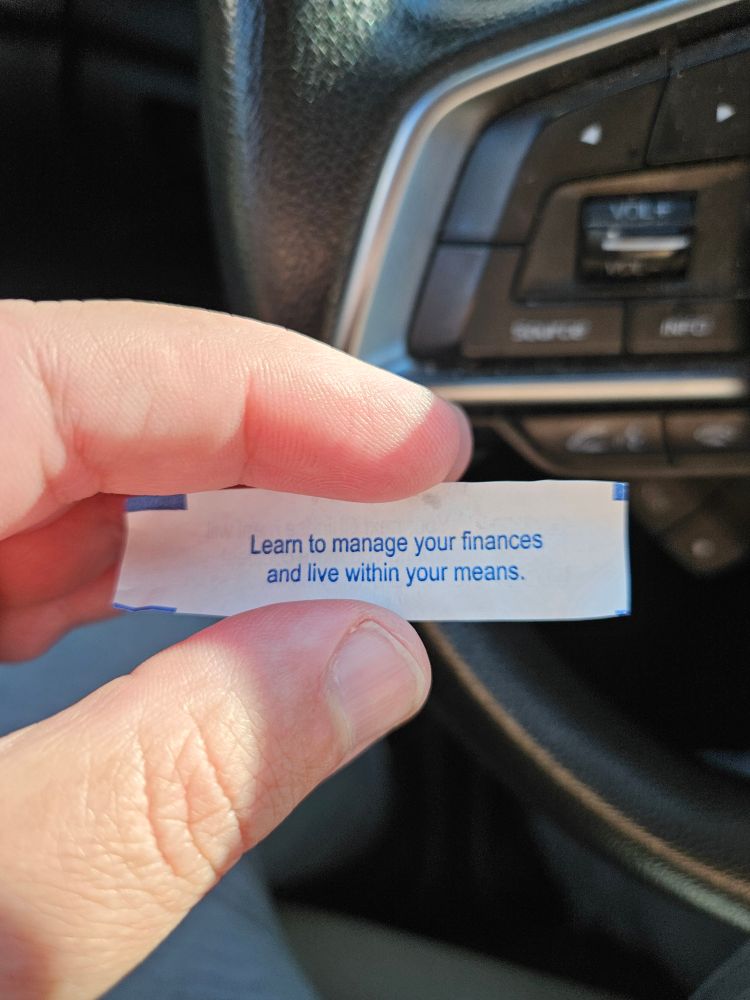 A fortune cookie reads "learn to manage your finances and live within your means."