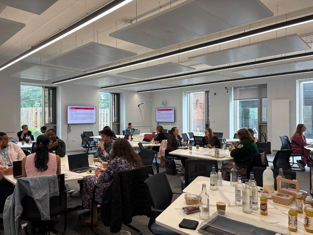 A room with multiple tables and people sitting 