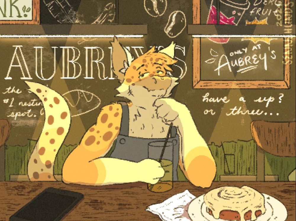 A spotted dragon sits in front of a wooden countertop with a clear green drink in hand. Their phone lays to the left, with a cinnamon roll on the right. The walls are decked with “Aubrey’s” a coffee shop.