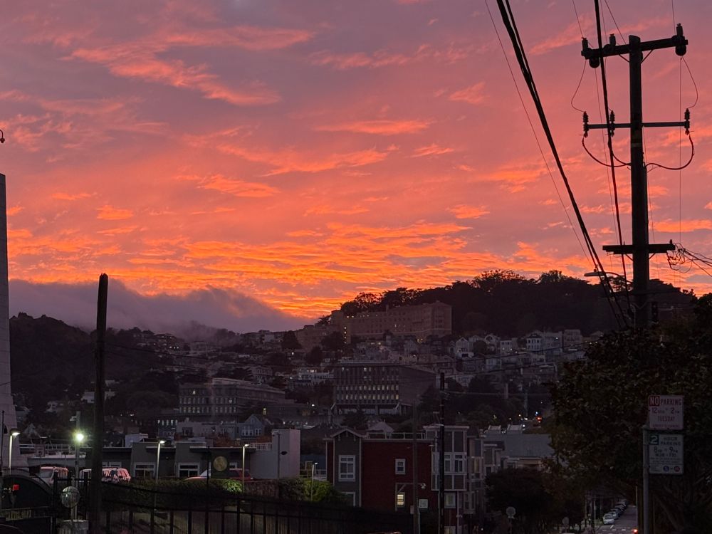 שקיעה צבעונית מאחורי גבעה