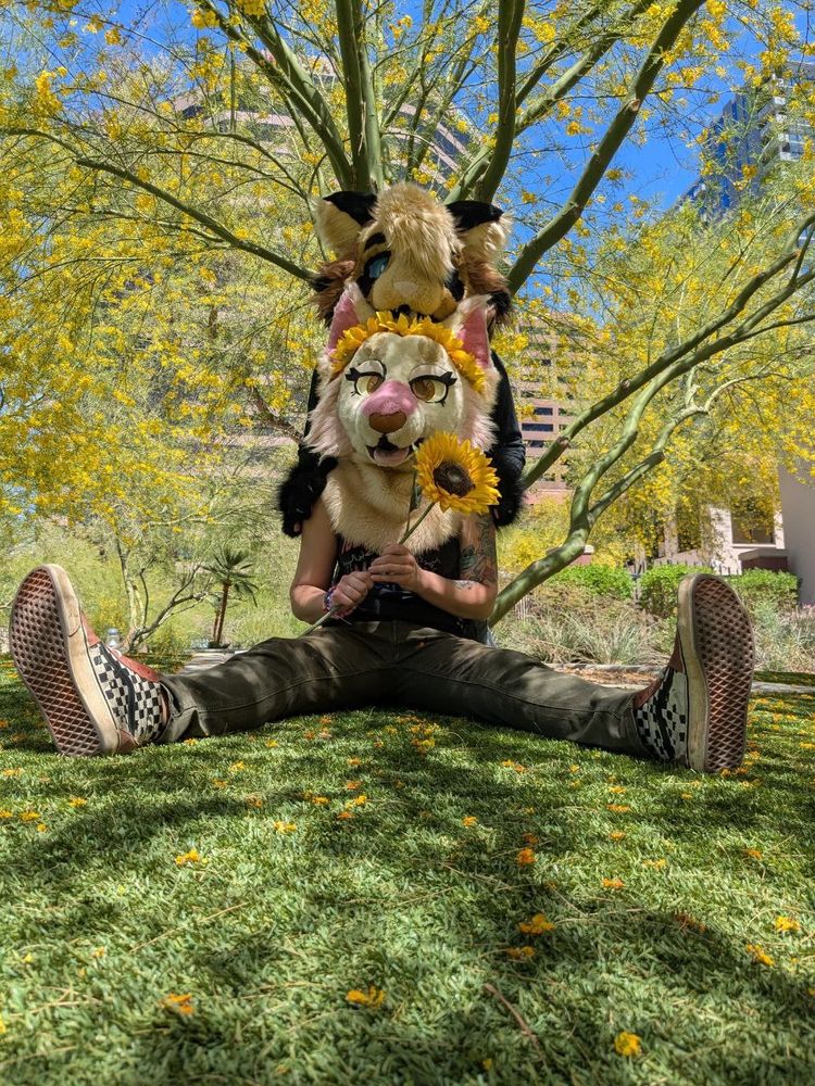Two cat fursuiters under a tree 