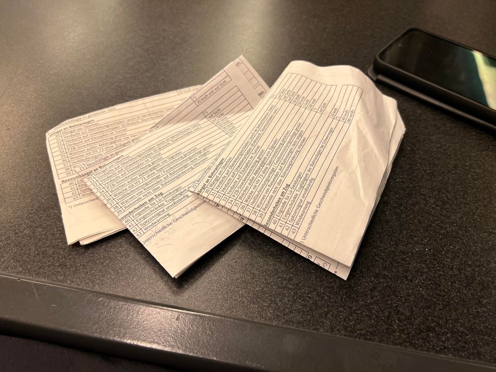 Drei umgedrehte, gefaltete Befehlsformulare auf einem Tisch.