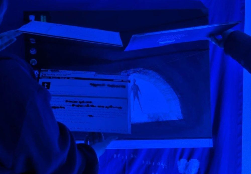 Photo of my friends interacting with the piece, lifting the panels to read the backs 