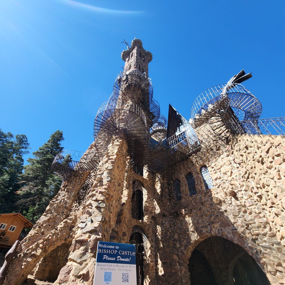 Stone castle with metal walkways on the outside and a dragons head adorning the front.