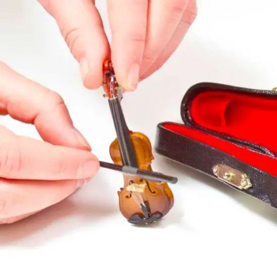 Picture showing a pair of hands playing "the world's smallest violin" 