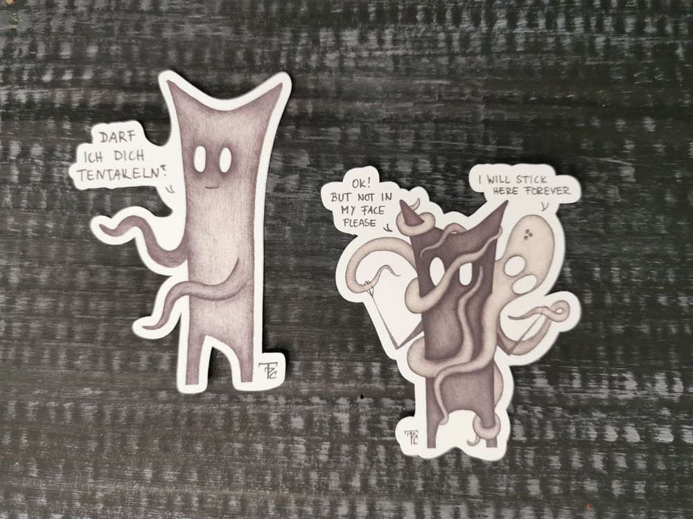 Auf dunklem Hintergrund liegen zwei Sticker. Der linke ist eine geistartige Figur mit großen, leeren Augen und zwei Spitzen am Kopf. Als Arme hat sie zwei Tentakel. Sie schaut freundlich. Links daneben steht ein Text: 'Darf ich dich tentakeln?’. Der rechte Sticker ist ebenfalls eine geistartige Figur mit großen, leeren Augen und zwei Spitzem am Kopf. An ihr hängt an Oktopus, der die Tentakel überall am Körper des Ghosties hat. Der Ghostie hält zwei Tentakel von sich weg. Über dem Oktopus steht folgendes: I Will Stick Here Forever. Links neben dem Ghostie steht: OK! But Not In My Face Please.