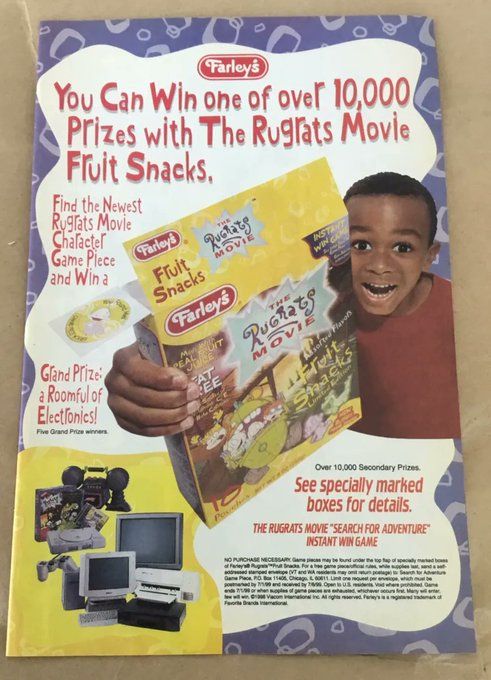 A child in a red shirt hold up a yellow box, which features images from The Rugrats Movie. In the bottom corner is an image of video game systems, TVs, and computers, which were prizes in a sweepstakes related to the product