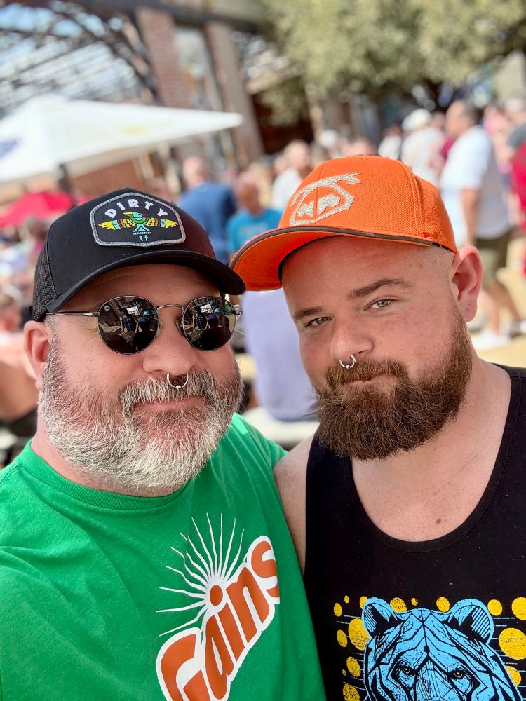 Muscle dad and muscle housemate at TBRU wearing hats and septum piercings 