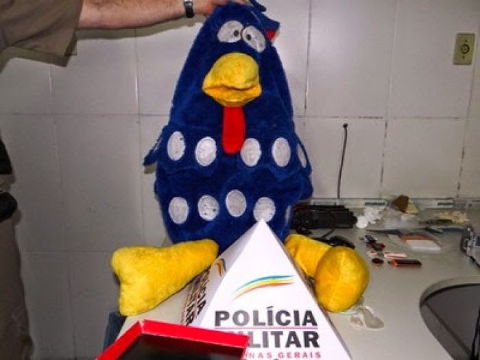 A Galinha Pintadinha doll held by a police officer. DrugBust 