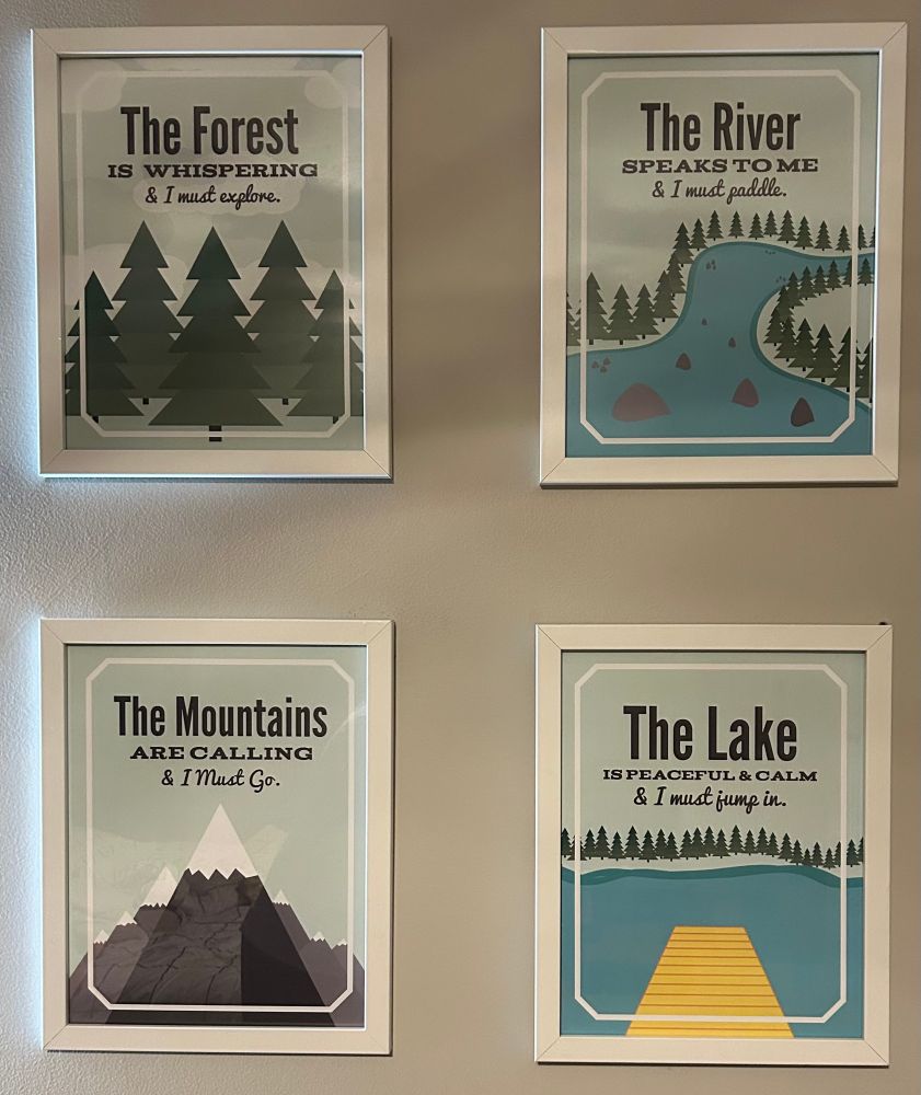4 framed prints with simple nature illustrations hanging on a wall with text at the top of each
1. The forest is whispering and i must explore
2. The river speaks to me and i must paddle
3. The mountains are calling and i must go
4. The lake is peaceful and calm and i must jump in