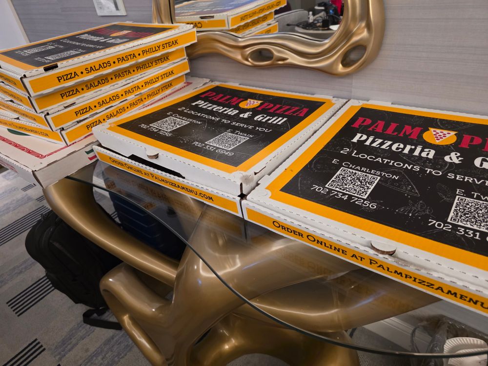 7 boxes of pizza with a variety of toppings
