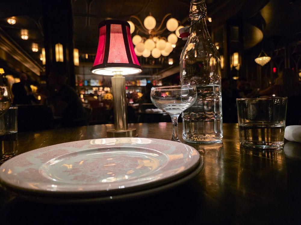 At Bavette's with a picture of the plate, wine glass, water glass and table lamp with a 1920's aesthetic in the background