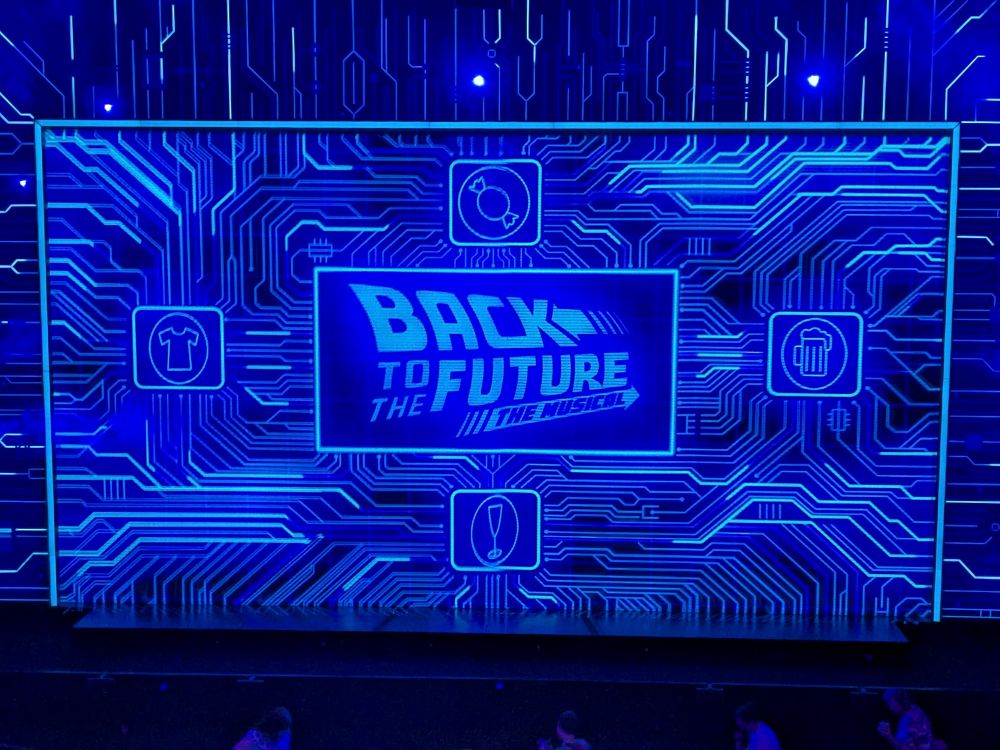 A splash screen reading Back to the Future the Musical, with blue electrical styling.