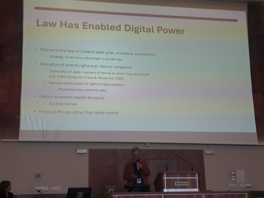 A person standing below a screen with a presentation 