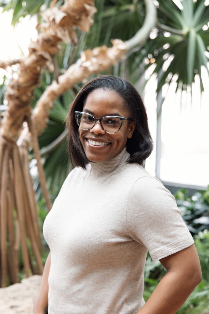 Dr. Andrene Wright-Johnson, political scientist, poses in front of botanical garden scene.