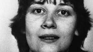 Schwarz-weißes Portraitfoto von Menignon, vermutlich bei einer Festnahme geschossen.