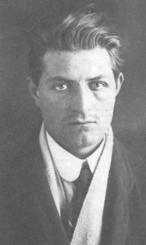 Portraitfoto von di Giovanni, er trägt Anzug, Hemd, Schlips. Auf eioner kolorierten Version des Bildes istz zu sehen, dass er ein blaues Auge hat, vermutlich ist das Foto also nach seiner Festnahme gemacht worden.