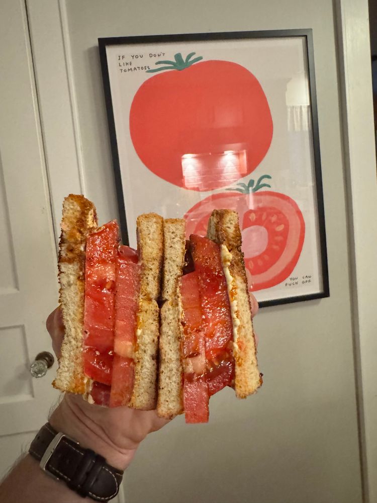 Tomato sandwich in front of tomato poster 