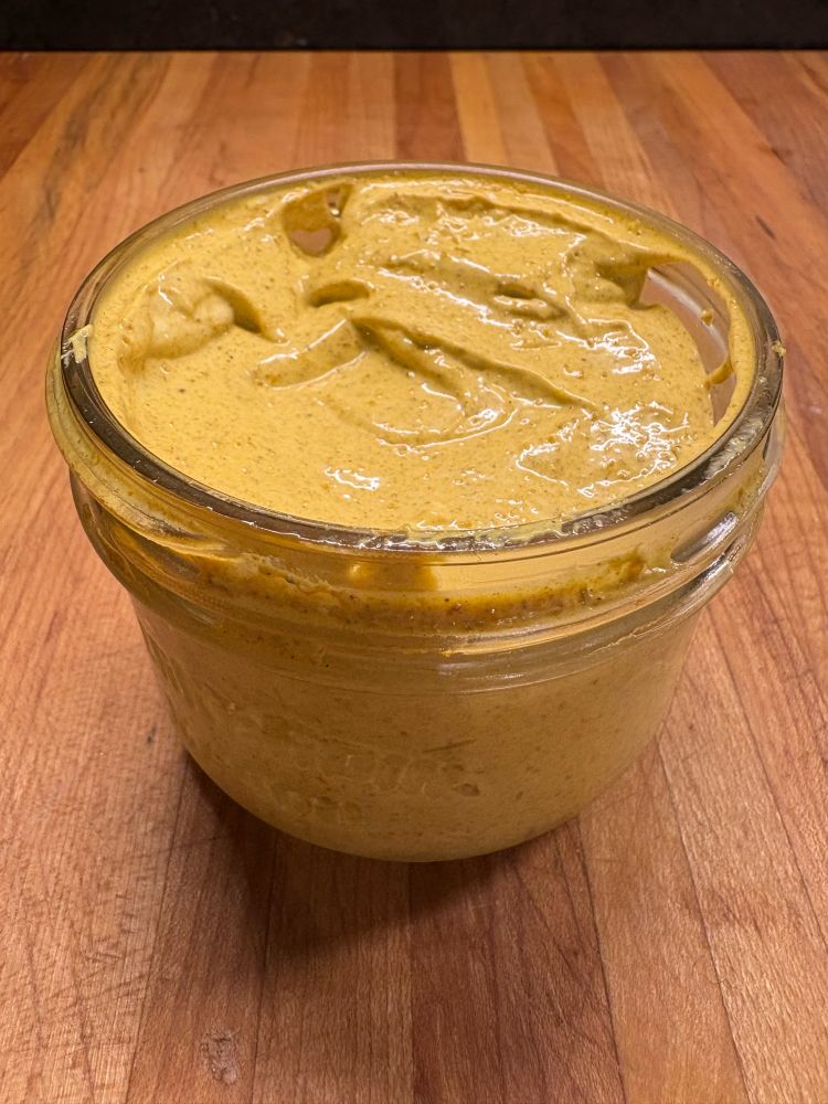 A small mason full of yellowish browning dip.