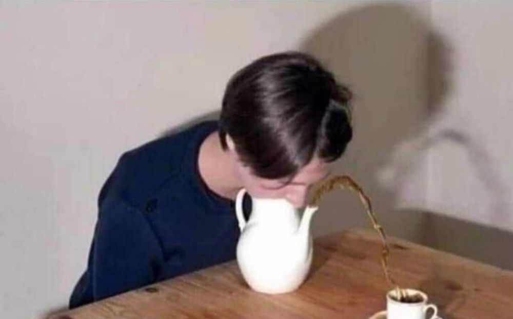Woman blowing into a teapot for force the tea out of the spout into a cup 