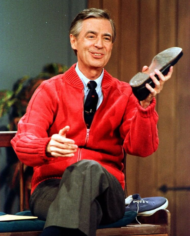 A smiling man wearing a bright red cardigan is sitting and holding a shoe in one hand.
Fred Rogers, in an undated photo, as "Mister Rogers" in a scene from the TV series, "Mister Rogers' Neighborhood"