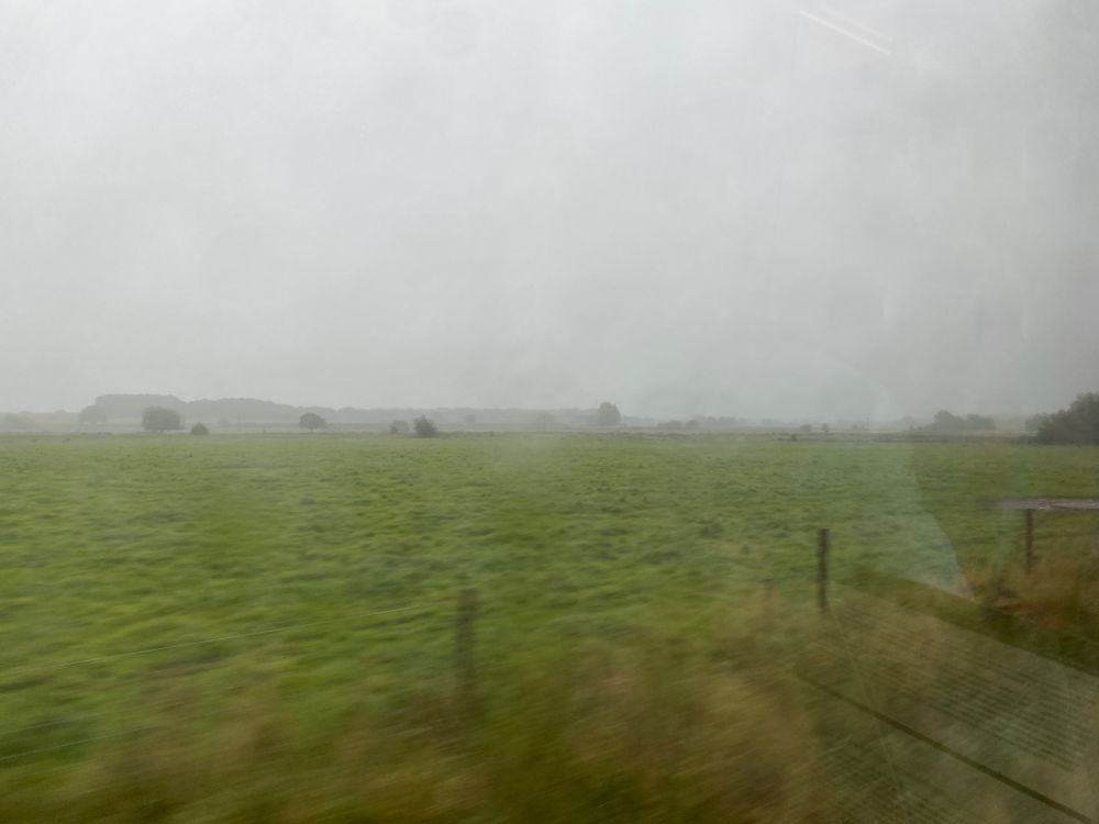 Photo of a rainy landscape from a train window