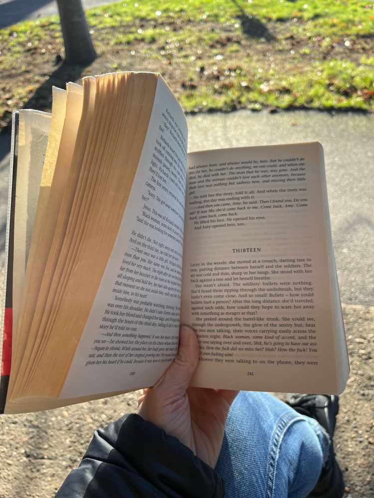 Justin Cronin’s The Passage being held open at page 241 (chapter thirteen) in front a sunny patch of grass 