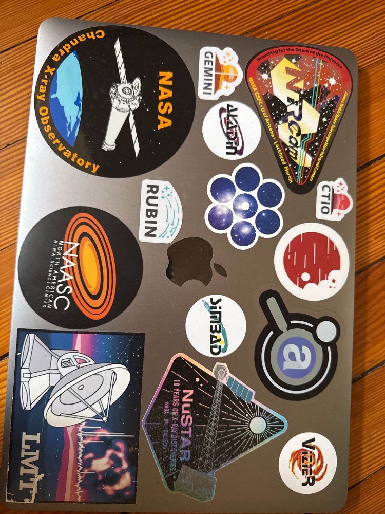 a macbook with an array of astronomy-related stickers, one of which is a "simbad" sticker, referring to the astronomical database.