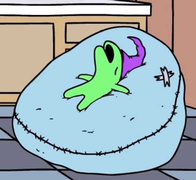 a little green creature sleeping with its mouth open on a bean bag chair