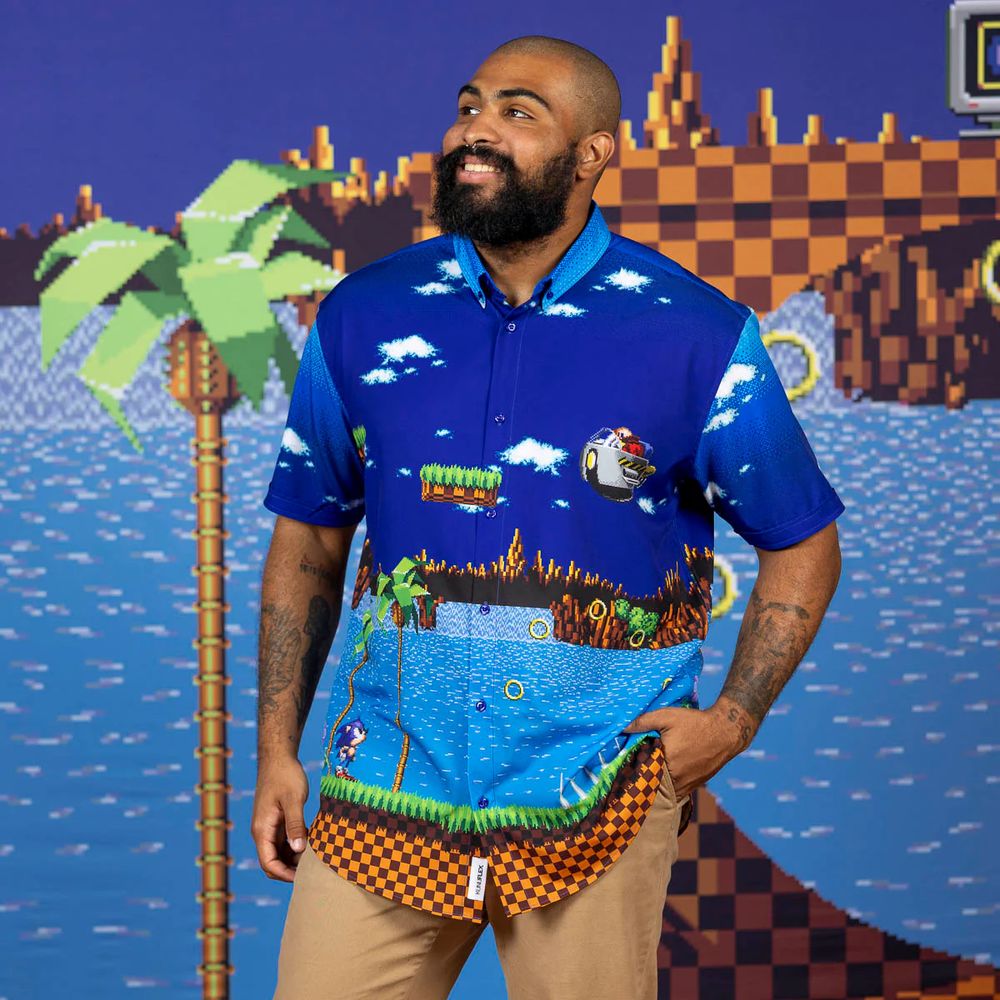 a bald man with a beard wearing the RSVLTS Sonic the Hedgehog "Green Hill Zone Showdown" shirt that's practically just a screenshot of Green Hill Zone Act 3