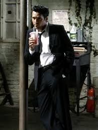 Une capture du film Reservoir Dogs où Michael Madsen est accoudé à un poteau et tenant un soda de fast-food 