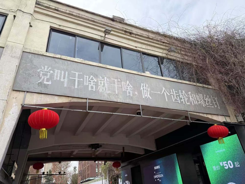 A sign on a Chinese street that 党叫干啥就干啥，做一个轮齿和螺丝钉 , in English “do whatever the party tells you to do, be a cog, be a screw” 