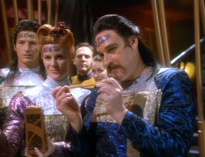 Members of the Wadi, a species of aliens with long black hair, facial tattoos, and sparkly uniforms that make them look like a big old bunch of game nerds in a glam rock band.