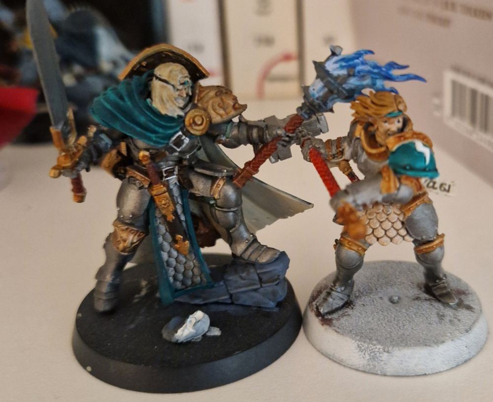 Deux figurines de Stormcast peintes avec des tons acier/or/vert.