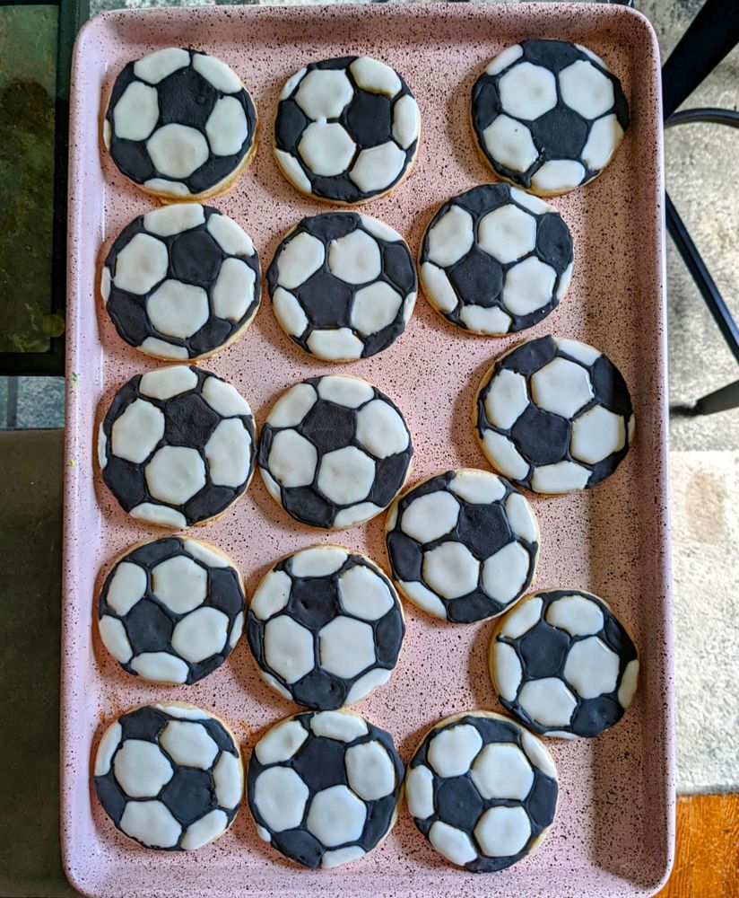 Sugar cookies on a pink tray decorated to look like soccer balls. I did a pretty good job on these.
