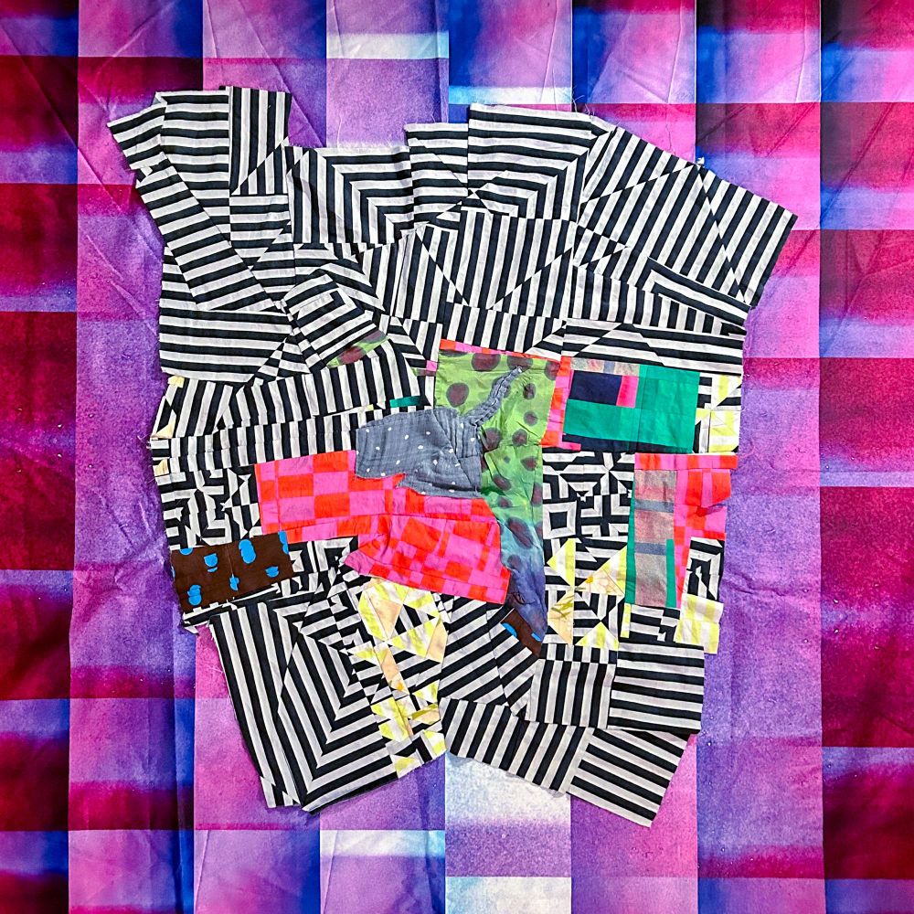 Abstract op art ish quilt top with stripes on a purplish blue grid. 