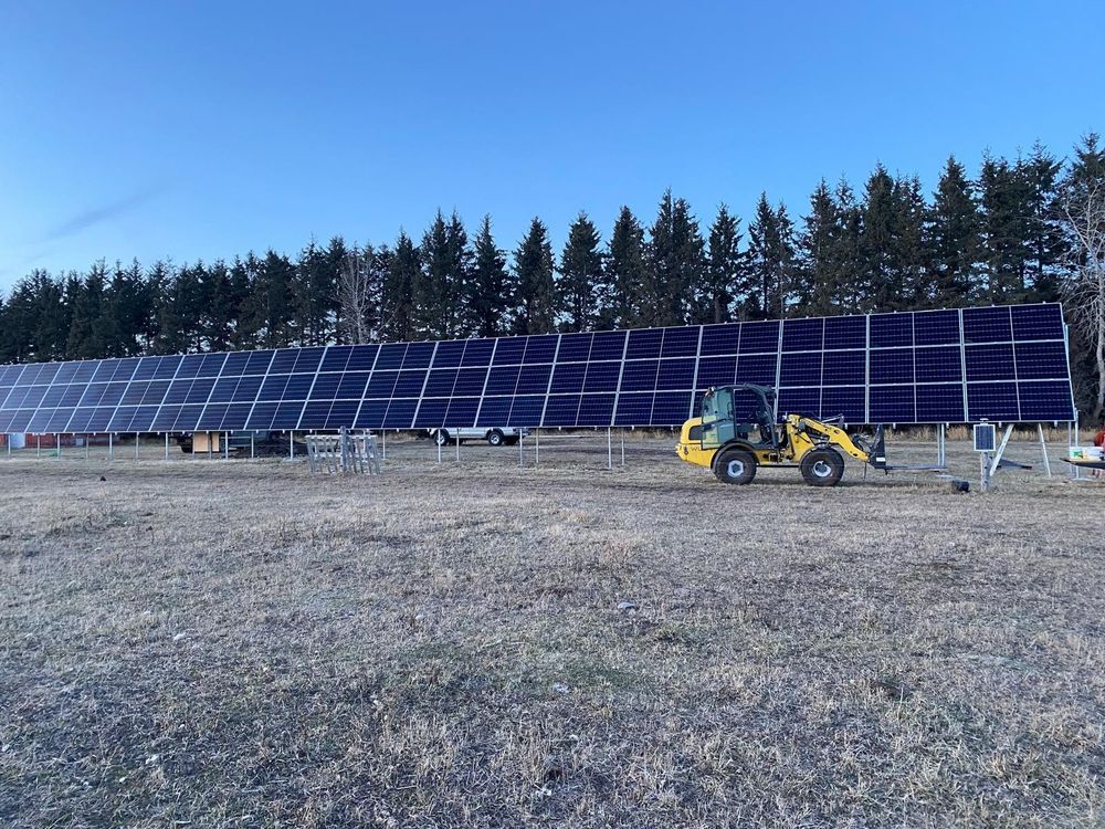 Photo of a solar array construction with a wheel loader in the foreground