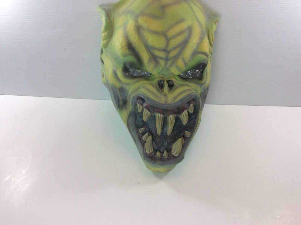 A front facing picture of a green monster mask with pointed ears and big fangs. 
