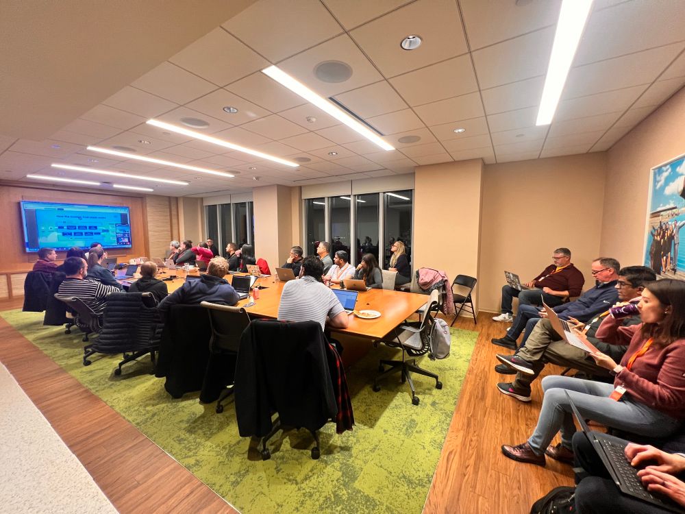 Salesforce professionals sitting in Boston Salesforce office with laptops.